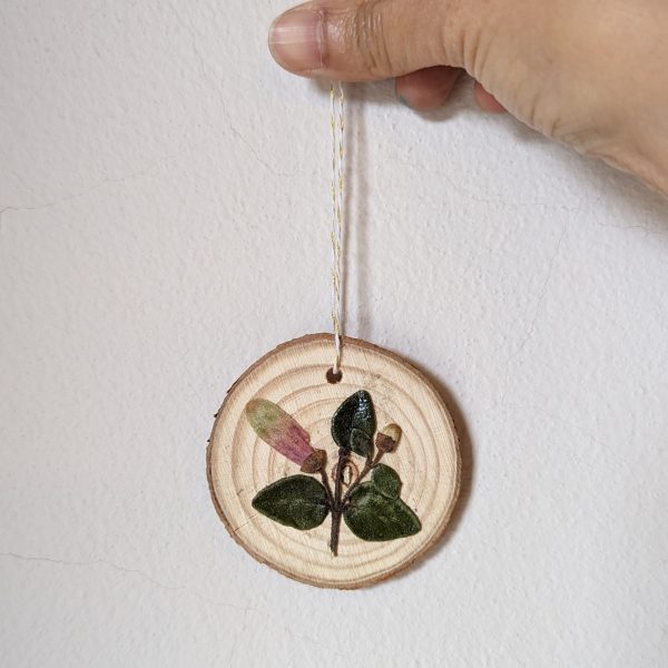 Wood Ornament with Pressed Flowers held by a hand