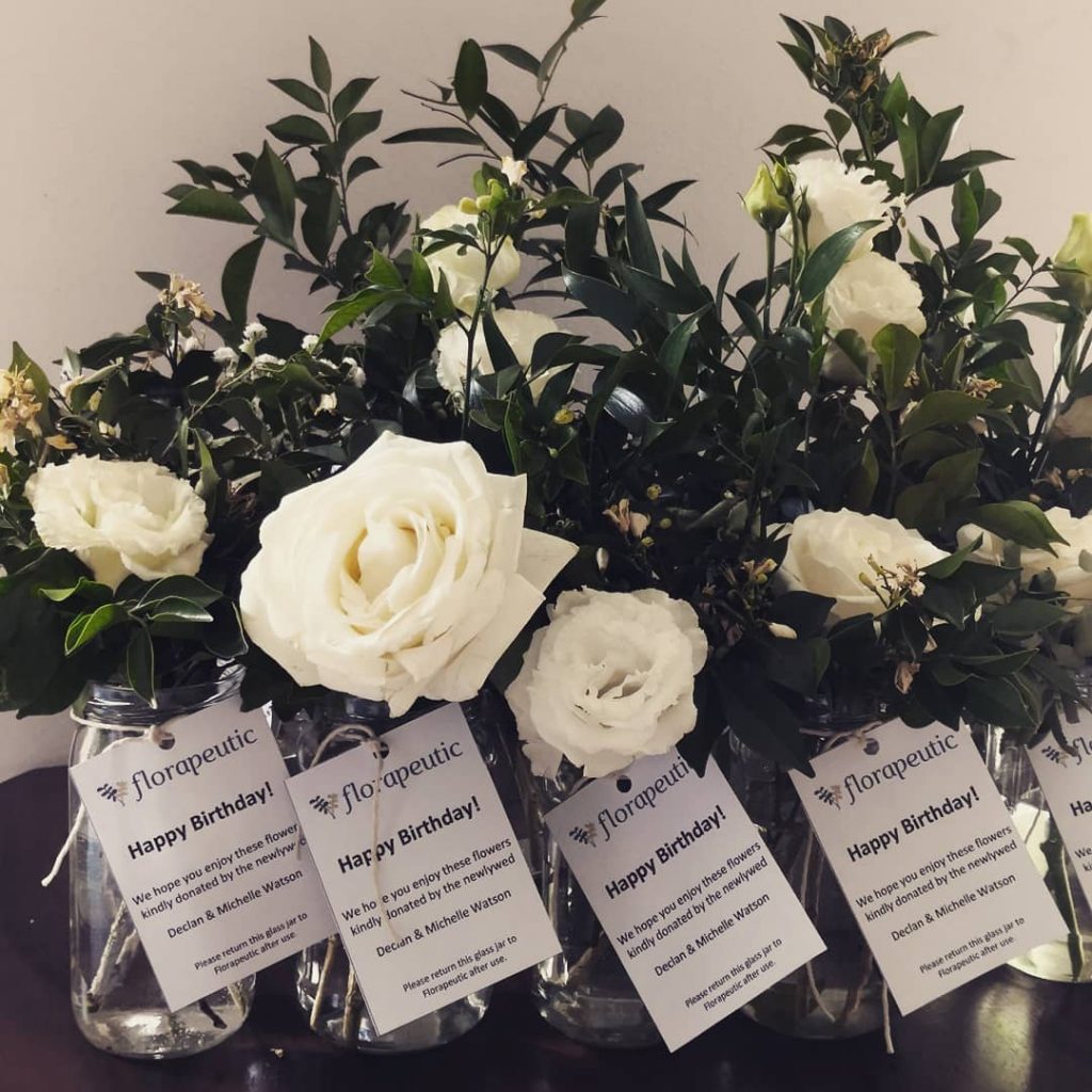 Donated white roses in glass jars with Happy Birthday tags